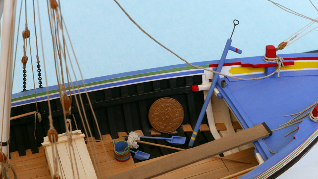 Model of a Portuguese Culé - bailers, bucket, rag mop, bilge pump, drinking mug, coin for scale